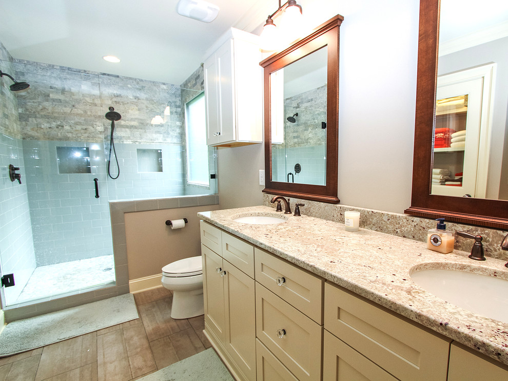 Photo of a medium sized traditional ensuite bathroom in Charlotte with a submerged sink, shaker cabinets, yellow cabinets, granite worktops, a double shower, a two-piece toilet, blue tiles, stone tiles, grey walls and porcelain flooring.