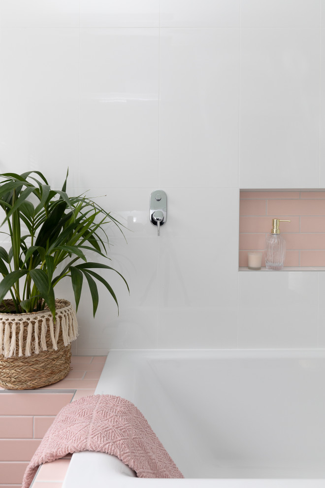 Modelo de cuarto de baño infantil, único y a medida contemporáneo pequeño con puertas de armario de madera oscura, bañera encastrada, combinación de ducha y bañera, baldosas y/o azulejos rosa, paredes blancas, suelo gris y encimeras blancas