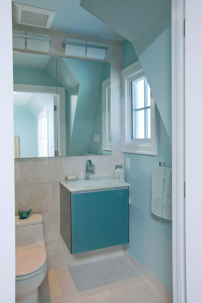 Kleines Modernes Duschbad mit flächenbündigen Schrankfronten, blauen Schränken, beigen Fliesen, Glaswaschbecken/Glaswaschtisch, offener Dusche, Toilette mit Aufsatzspülkasten, Porzellanfliesen, blauer Wandfarbe, Porzellan-Bodenfliesen und integriertem Waschbecken in Minneapolis