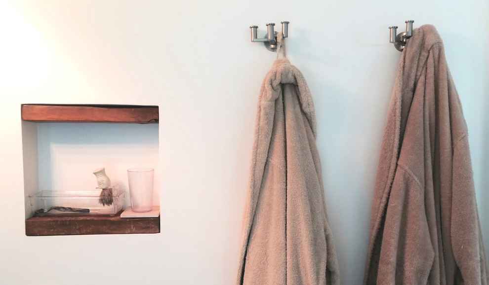 Cette image montre une petite salle d'eau design en bois brun avec une vasque, WC suspendus, un carrelage bleu, un carrelage en pâte de verre, un mur blanc, un sol en carrelage de céramique, un plan de toilette en bois et une douche à l'italienne.