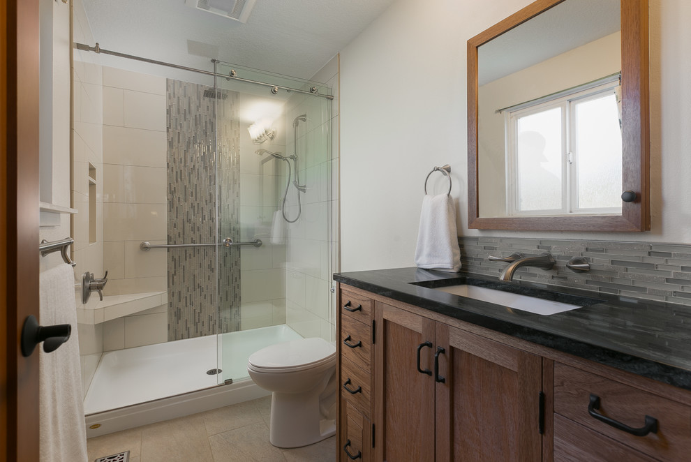 Exempel på ett litet klassiskt en-suite badrum, med luckor med infälld panel, skåp i mellenmörkt trä, en dusch i en alkov, en toalettstol med separat cisternkåpa, beige kakel, stenhäll, grå väggar, klinkergolv i porslin, ett undermonterad handfat och bänkskiva i täljsten