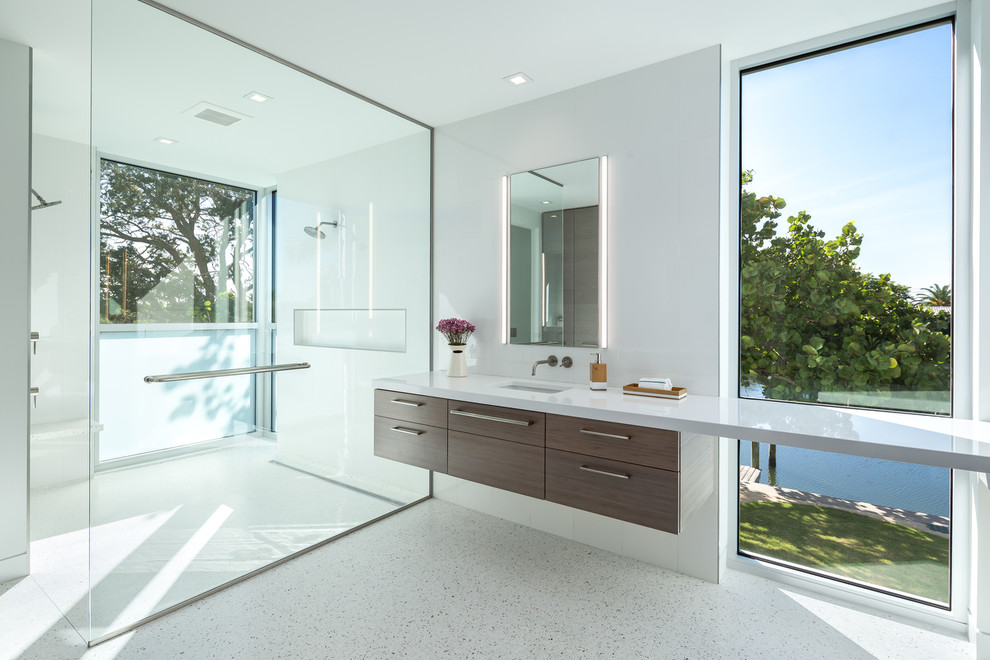 Inspiration pour une très grande salle de bain principale minimaliste en bois foncé avec un placard à porte plane, une douche à l'italienne, WC suspendus, un carrelage blanc, un mur blanc et un lavabo encastré.
