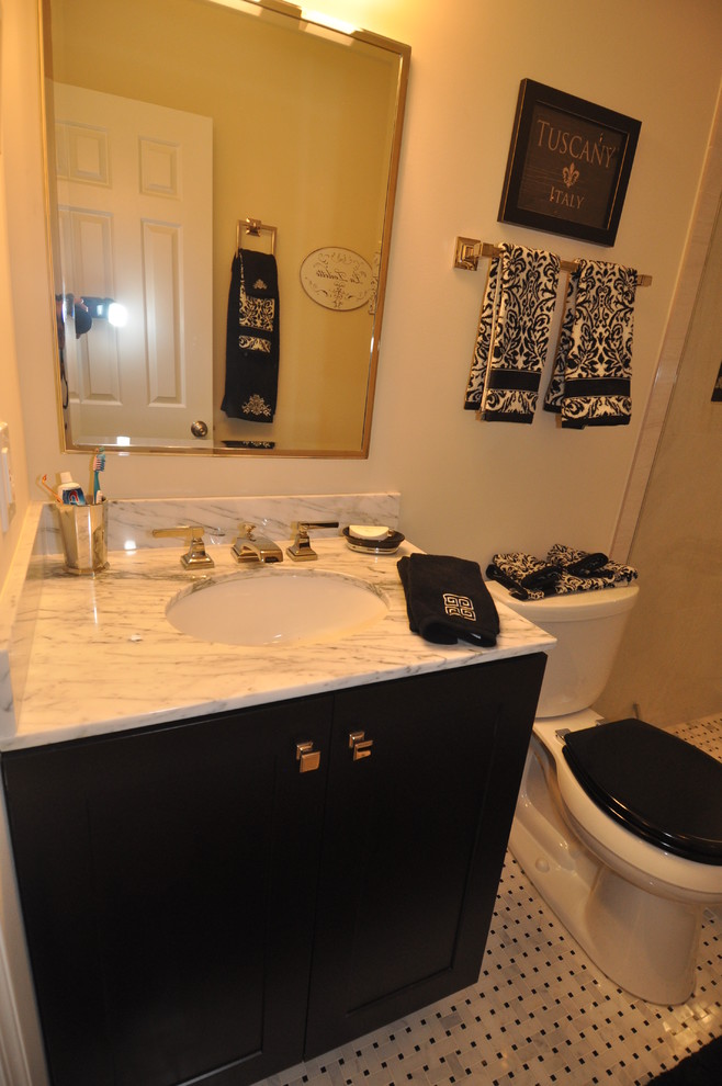 Esempio di una stanza da bagno padronale moderna di medie dimensioni con lavabo sottopiano, ante nere e top in marmo