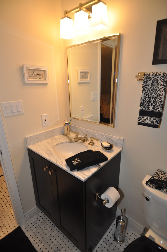 Immagine di una stanza da bagno padronale moderna di medie dimensioni con lavabo sottopiano, ante nere e top in marmo