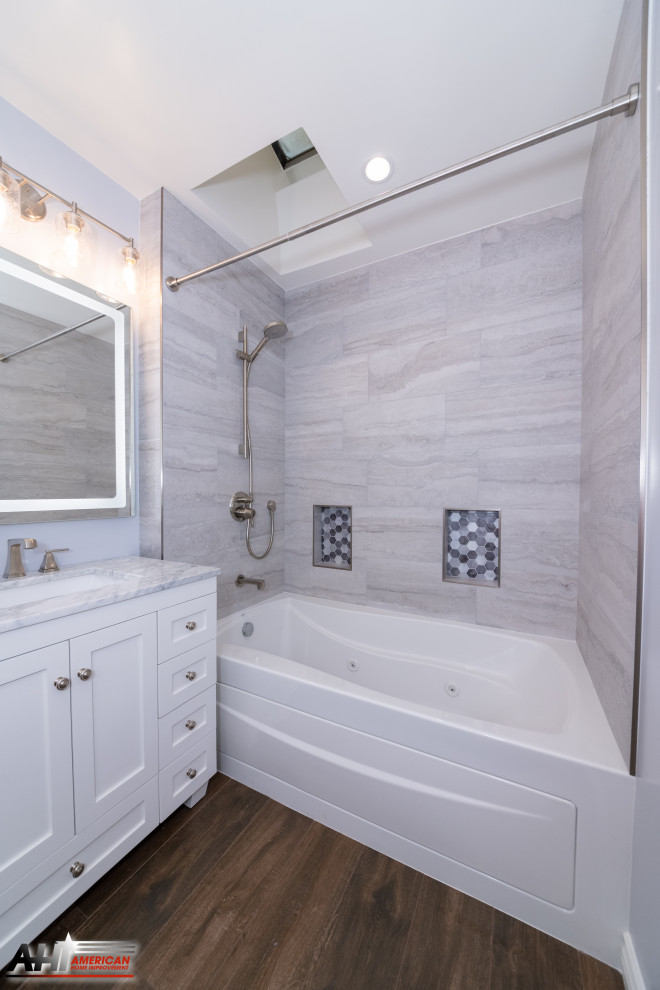 Стильный дизайн: ванная комната среднего размера в стиле модернизм с плоскими фасадами, белыми фасадами, гидромассажной ванной, душем над ванной, унитазом-моноблоком, серой плиткой, керамогранитной плиткой, серыми стенами, полом из цементной плитки, душевой кабиной, врезной раковиной, столешницей из кварцита, коричневым полом, шторкой для ванной, серой столешницей, нишей, тумбой под одну раковину, встроенной тумбой и многоуровневым потолком - последний тренд