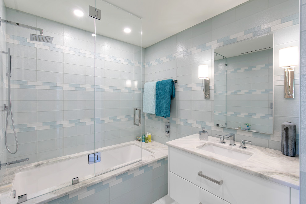 Esempio di una stanza da bagno contemporanea con ante lisce, ante bianche, vasca ad alcova, vasca/doccia, piastrelle blu, piastrelle di vetro, lavabo sottopiano, doccia aperta, top bianco, un lavabo e mobile bagno sospeso