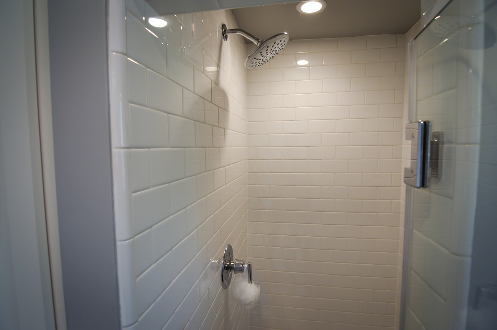 Inspiration för små moderna vitt badrum med dusch, med skåp i shakerstil, blå skåp, en hörndusch, en toalettstol med separat cisternkåpa, vit kakel, porslinskakel, grå väggar, laminatgolv, ett undermonterad handfat, bänkskiva i kvarts, brunt golv och dusch med gångjärnsdörr