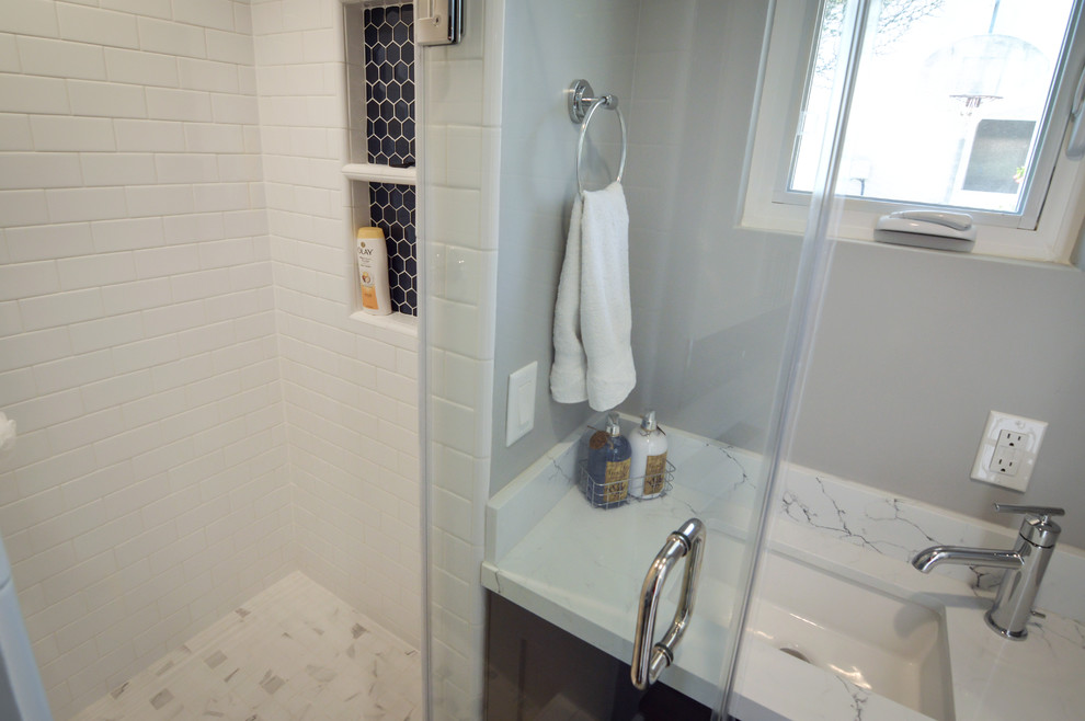 Modern inredning av ett litet vit vitt badrum med dusch, med skåp i shakerstil, blå skåp, en hörndusch, en toalettstol med separat cisternkåpa, vit kakel, porslinskakel, grå väggar, laminatgolv, ett undermonterad handfat, bänkskiva i kvarts, brunt golv och dusch med gångjärnsdörr