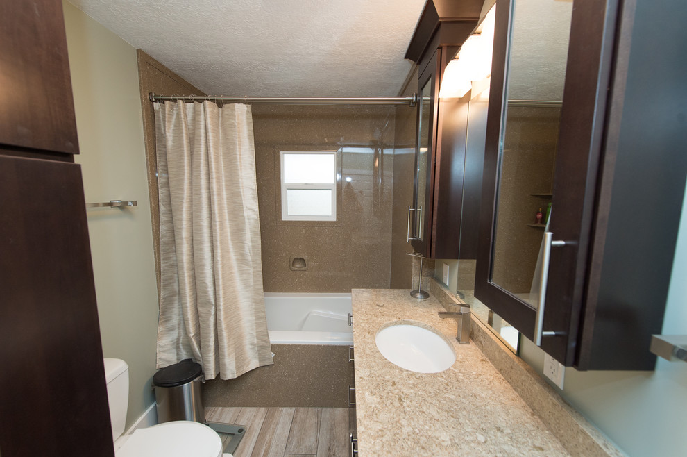 Idéer för att renovera ett mellanstort vintage badrum med dusch, med släta luckor, bruna skåp, ett badkar i en alkov, en dusch/badkar-kombination, en toalettstol med separat cisternkåpa, gröna väggar, klinkergolv i porslin, ett undermonterad handfat, bänkskiva i kvarts, brunt golv och dusch med duschdraperi