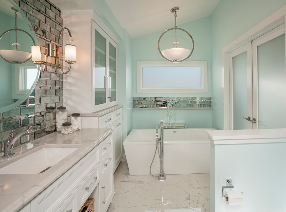 Inredning av ett modernt mellanstort en-suite badrum, med luckor med infälld panel, vita skåp, ett fristående badkar, en dusch i en alkov, en toalettstol med hel cisternkåpa, grå kakel, spegel istället för kakel, blå väggar, marmorgolv, ett undermonterad handfat och marmorbänkskiva