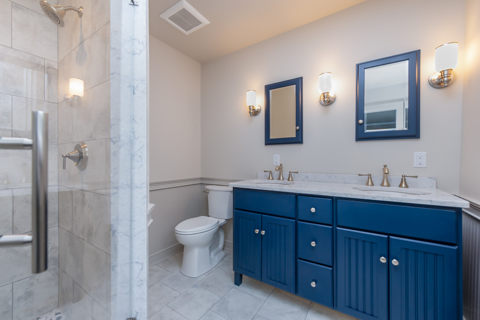 Transitional porcelain tile and gray floor alcove shower photo in New York with beaded inset cabinets, blue cabinets, a two-piece toilet, beige walls, an undermount sink, quartz countertops, a hinged shower door and gray countertops