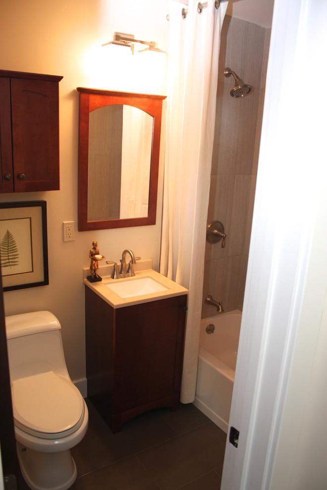 Cette image montre une petite salle d'eau traditionnelle en bois brun avec un lavabo encastré, un placard à porte shaker, un plan de toilette en quartz modifié, une baignoire indépendante, un combiné douche/baignoire, WC à poser, des carreaux de porcelaine, un mur beige, un sol en carrelage de porcelaine et un carrelage beige.