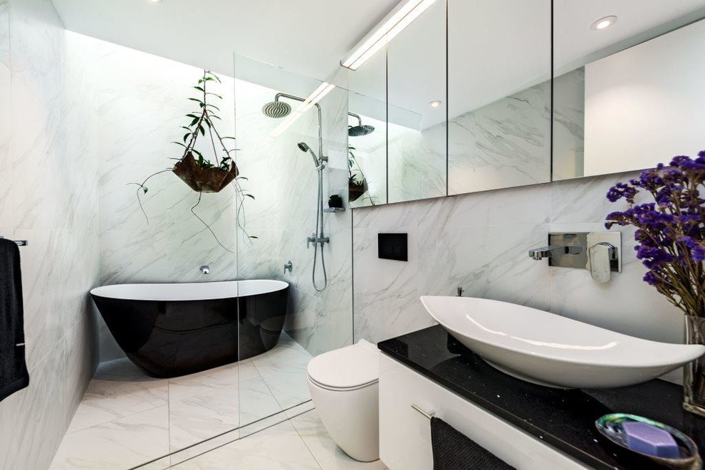 Idéer för ett mellanstort modernt svart en-suite badrum, med vita skåp, vita väggar, klinkergolv i porslin, ett fristående handfat och bänkskiva i kvarts
