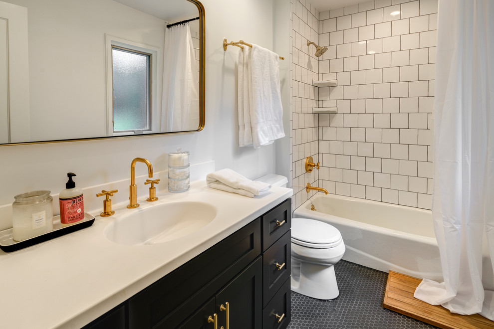 Modern inredning av ett litet badrum med dusch, med släta luckor, skåp i mörkt trä, ett badkar i en alkov, en dusch/badkar-kombination, en toalettstol med separat cisternkåpa, svart och vit kakel, keramikplattor, grå väggar, klinkergolv i porslin, ett integrerad handfat och bänkskiva i akrylsten