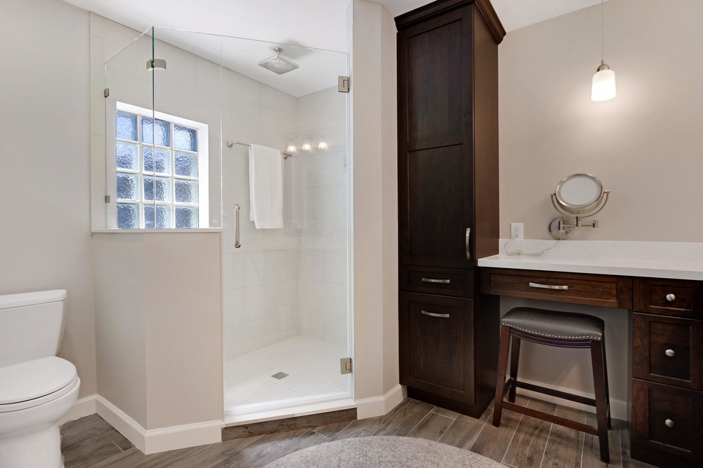 Exemple d'une salle de bain chic avec un placard à porte shaker, une douche d'angle, un mur gris, un sol en carrelage de porcelaine, un plan de toilette en surface solide, un sol gris et une cabine de douche à porte battante.