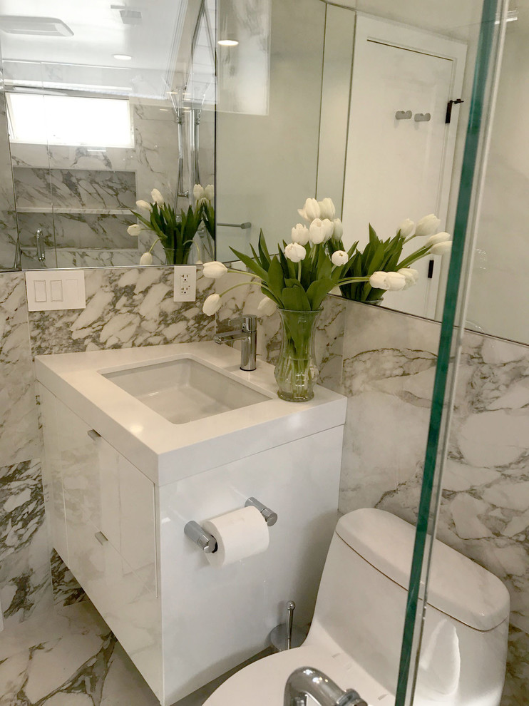 Modern inredning av ett litet badrum för barn, med vita skåp, en vägghängd toalettstol, svart och vit kakel, porslinskakel, flerfärgade väggar, klinkergolv i porslin, flerfärgat golv och dusch med gångjärnsdörr