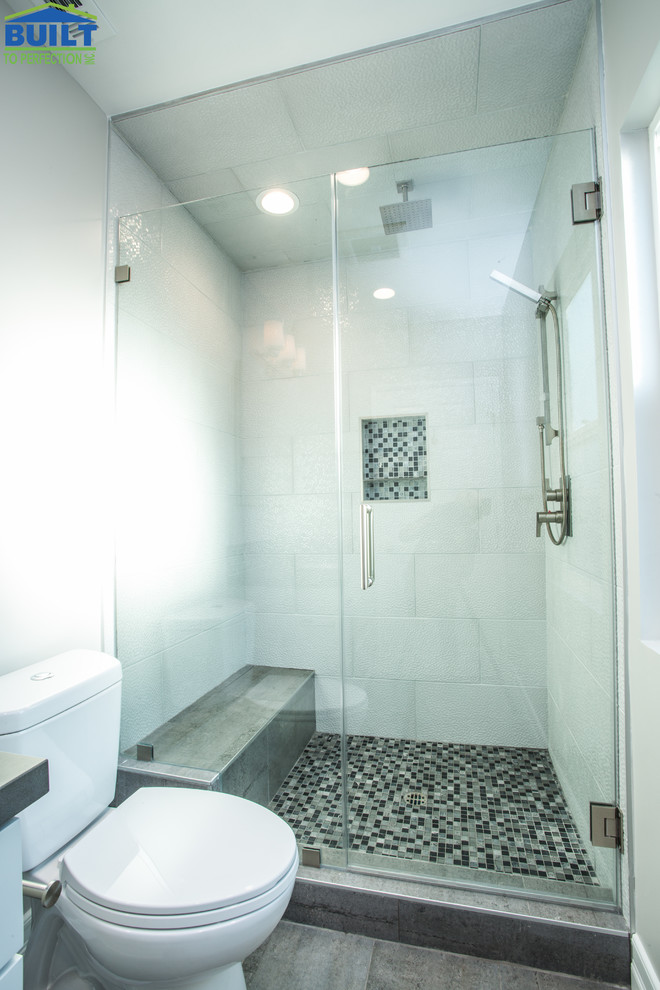 Photo of a medium sized traditional shower room bathroom in Los Angeles with shaker cabinets, white cabinets, an alcove shower, a two-piece toilet, blue tiles, multi-coloured tiles, glass sheet walls, white walls, ceramic flooring, a submerged sink, grey floors, a hinged door and grey worktops.