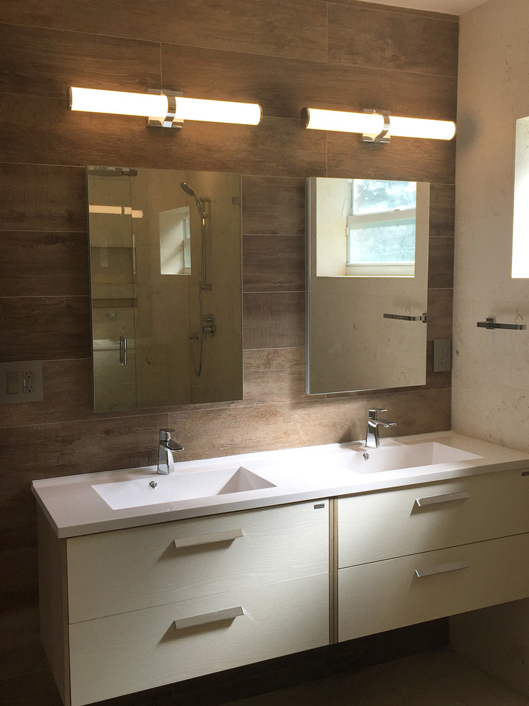 На фото: главная ванная комната в стиле модернизм с плоскими фасадами, светлыми деревянными фасадами, угловым душем, унитазом-моноблоком, керамогранитной плиткой, полом из травертина и душем с распашными дверями