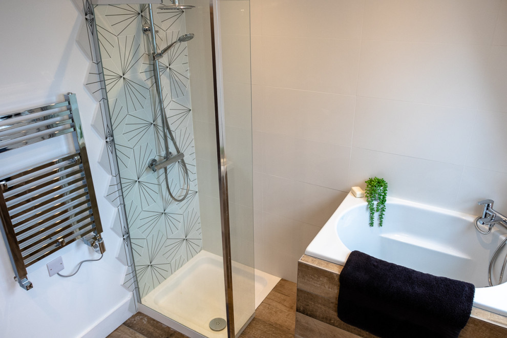 Photo of a medium sized contemporary family bathroom in London with white cabinets, a japanese bath, a walk-in shower, a one-piece toilet, white tiles, ceramic tiles, white walls, cement flooring, granite worktops, brown floors, a hinged door and black worktops.