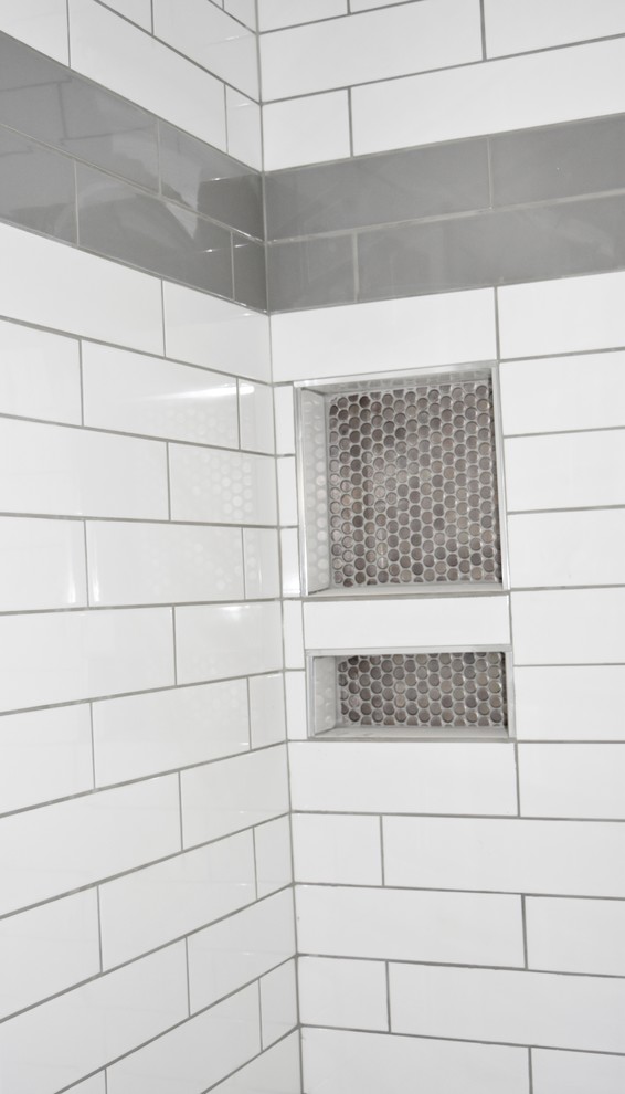アトランタにある高級な中くらいなトランジショナルスタイルのおしゃれな浴室 (インセット扉のキャビネット、白いキャビネット、コーナー設置型シャワー、グレーのタイル、サブウェイタイル、白い壁、淡色無垢フローリング、クオーツストーンの洗面台) の写真