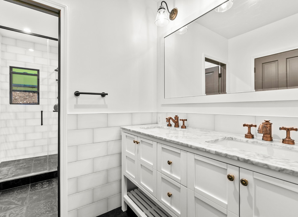 Cette photo montre une grande salle de bain principale chic avec un placard à porte shaker, des portes de placard blanches, un carrelage blanc, un carrelage métro, un mur blanc, un sol en carrelage de porcelaine, un sol noir et un plan de toilette blanc.