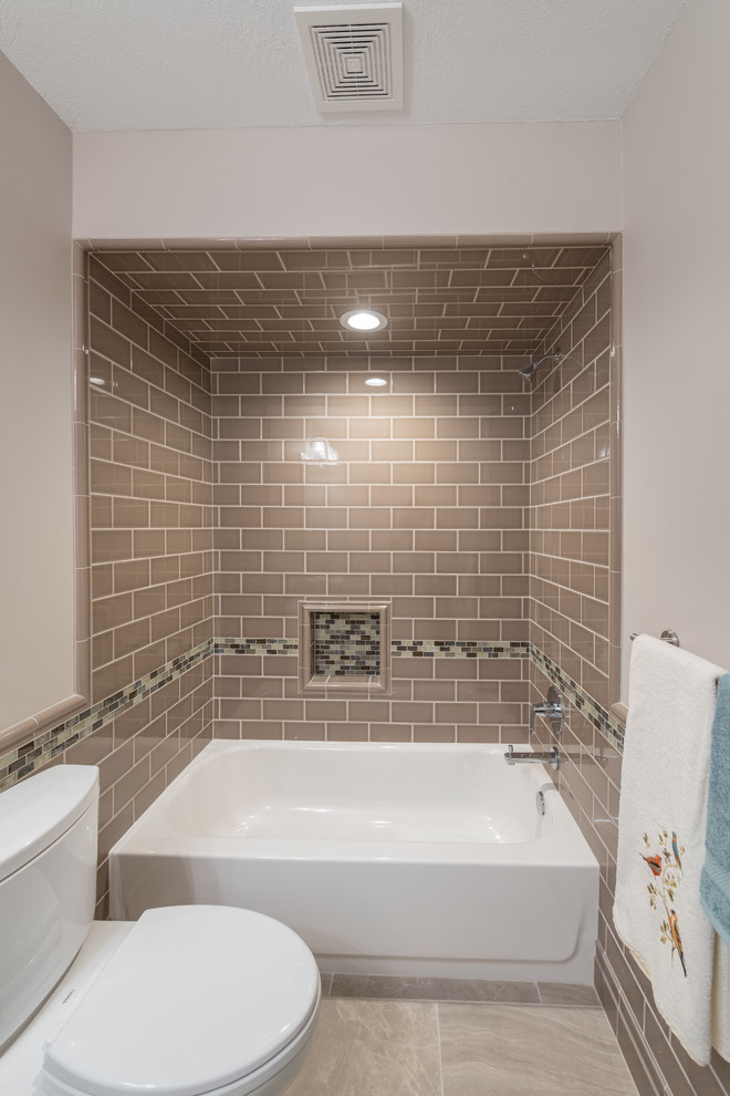 Mid-sized elegant 3/4 brown tile and subway tile porcelain tile and beige floor bathroom photo in Minneapolis with raised-panel cabinets, white cabinets, a two-piece toilet, beige walls, an undermount sink and quartz countertops