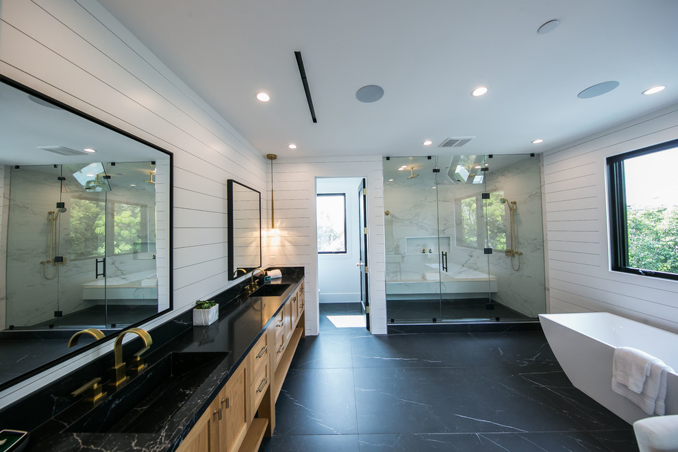 Design ideas for a large retro ensuite bathroom in Los Angeles with shaker cabinets, light wood cabinets, an alcove bath, a double shower, a one-piece toilet, grey tiles, stone tiles, white walls, marble flooring, a submerged sink, marble worktops, black floors, a hinged door and black worktops.