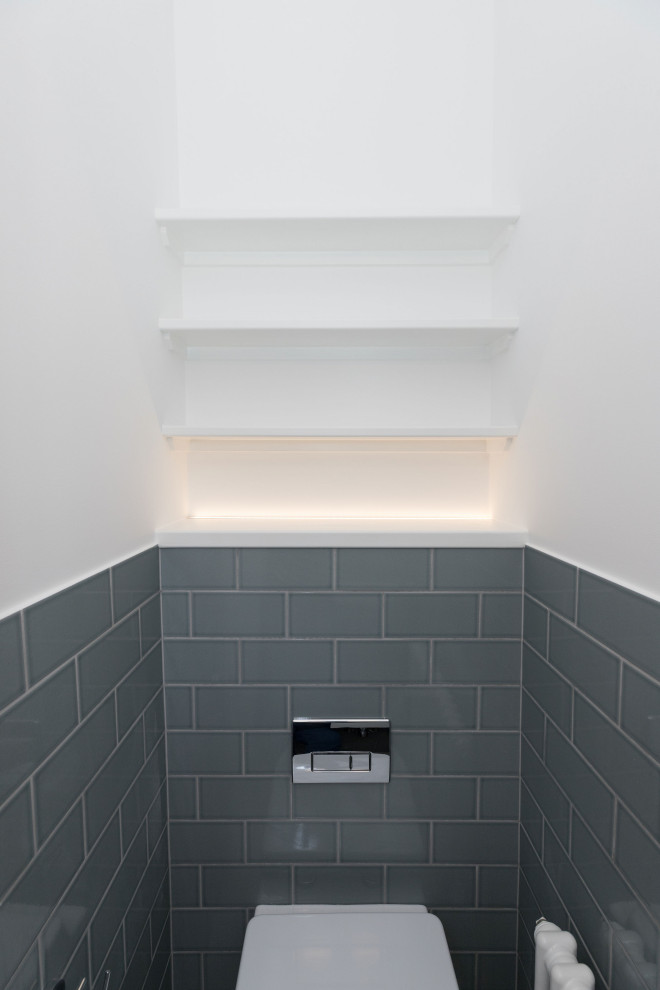 Réalisation d'une petite salle de bain minimaliste avec WC suspendus, un carrelage multicolore, des carreaux de céramique, un mur multicolore, carreaux de ciment au sol, un lavabo suspendu, un sol gris, des toilettes cachées et meuble simple vasque.