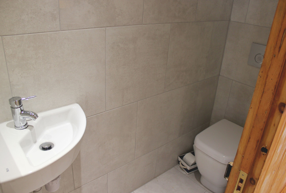 Foto di una piccola stanza da bagno per bambini design con lavabo sospeso, WC sospeso, piastrelle grigie, piastrelle in gres porcellanato, pareti grigie e pavimento in gres porcellanato