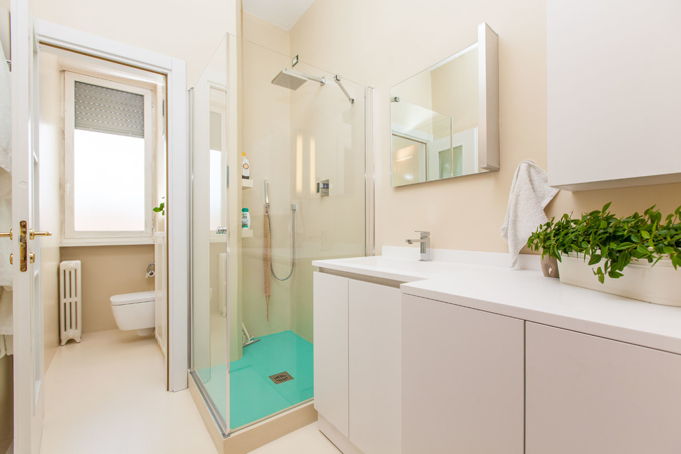 Modernes Badezimmer mit Eckdusche, Wandtoilette, weißer Wandfarbe, Porzellan-Bodenfliesen und integriertem Waschbecken in Mailand