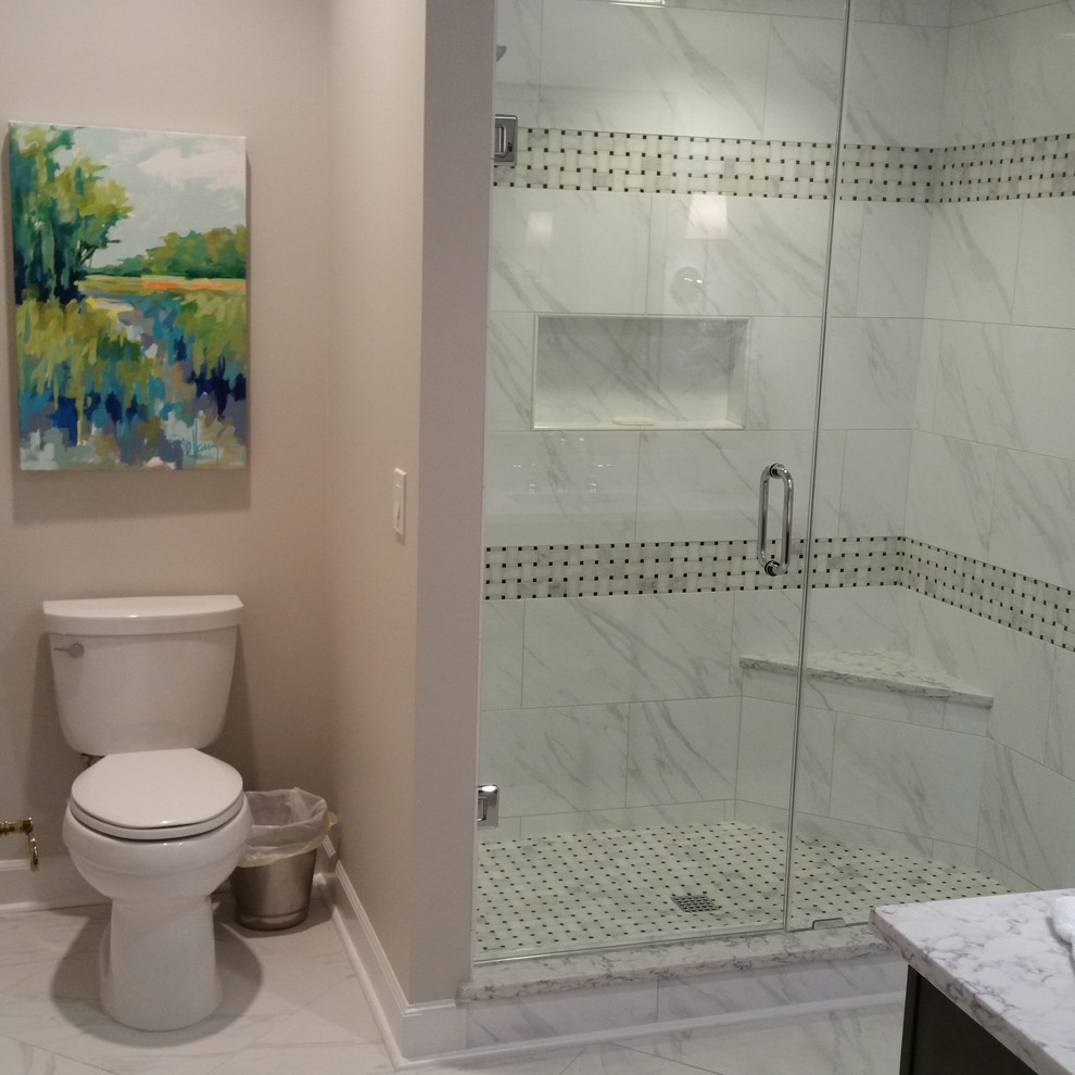 Klassisk inredning av ett mellanstort badrum med dusch, med luckor med upphöjd panel, grå skåp, en dusch i en alkov, vit kakel, marmorkakel, beige väggar, marmorgolv, ett undermonterad handfat, marmorbänkskiva, vitt golv och dusch med gångjärnsdörr