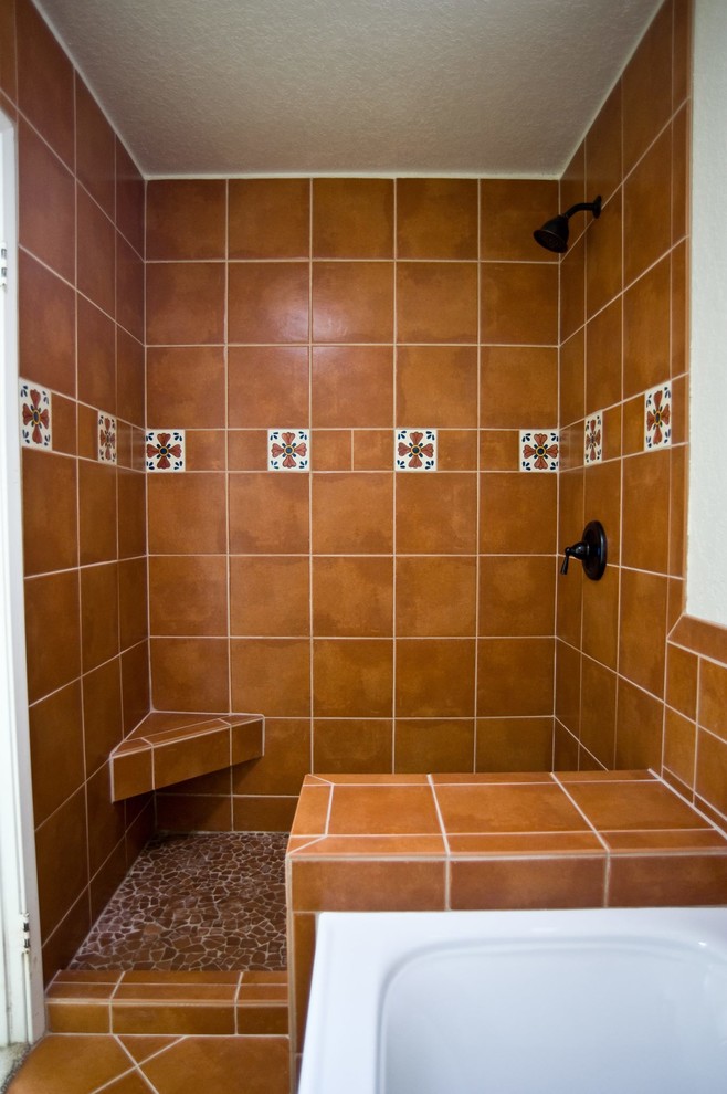 Foto på ett mellanstort amerikanskt badrum med dusch, med med dusch som är öppen, en dusch i en alkov, orange kakel, perrakottakakel, klinkergolv i terrakotta, ett integrerad handfat och brunt golv