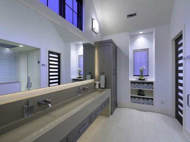 Esempio di una grande stanza da bagno padronale minimal con ante con riquadro incassato, ante grigie, pareti bianche, pavimento in gres porcellanato, lavabo rettangolare e top in superficie solida