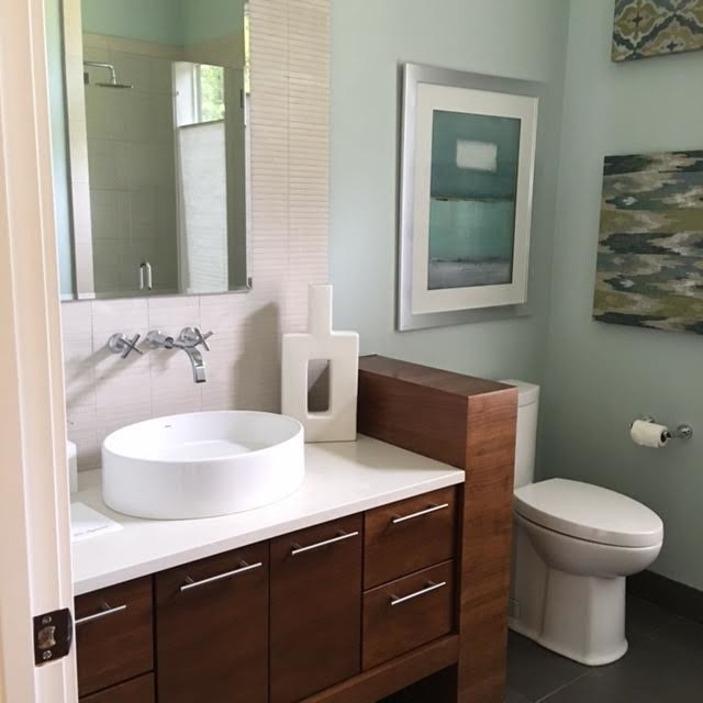 Mid-sized trendy 3/4 beige tile and matchstick tile slate floor and gray floor alcove shower photo in Portland with flat-panel cabinets, dark wood cabinets, a two-piece toilet, blue walls, a vessel sink, laminate countertops and a hinged shower door