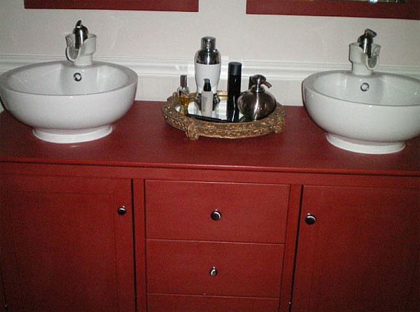 Aménagement d'une salle de bain campagne de taille moyenne avec un placard en trompe-l'oeil, des portes de placard rouges, un mur blanc, une vasque et un plan de toilette en bois.