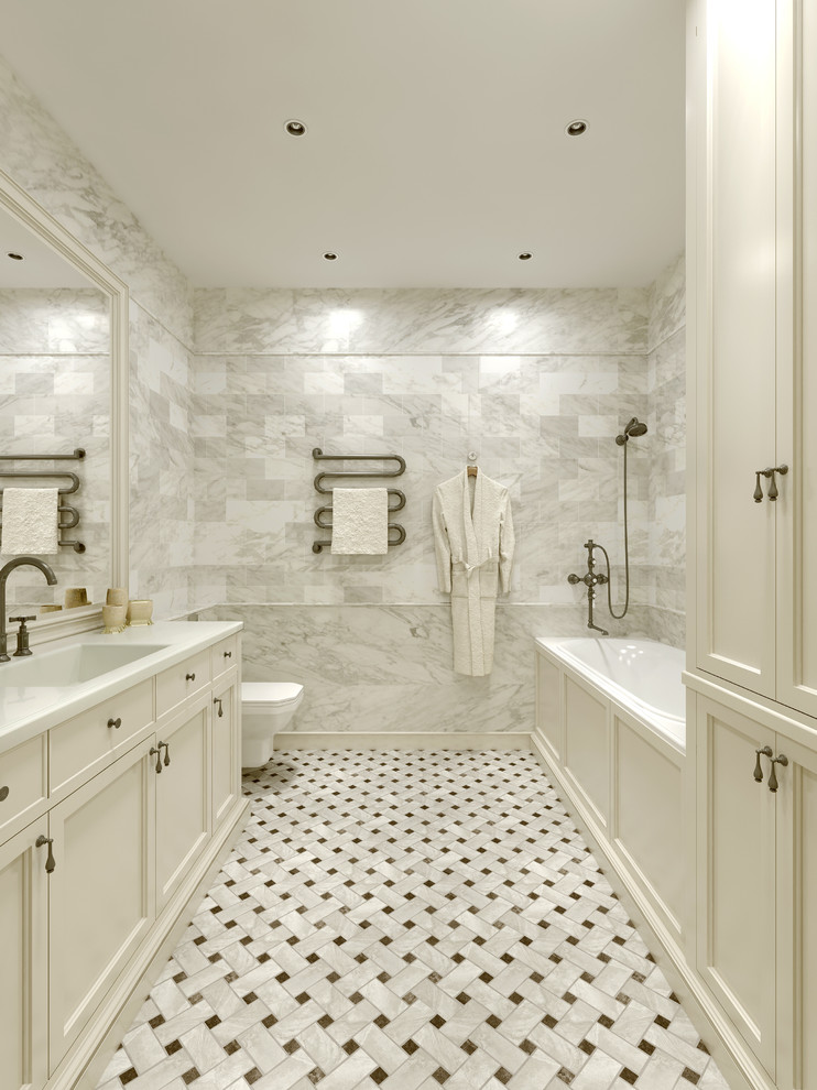 Cette image montre une salle de bain principale traditionnelle avec un placard avec porte à panneau encastré, des portes de placard blanches, une baignoire posée, un combiné douche/baignoire et un lavabo encastré.
