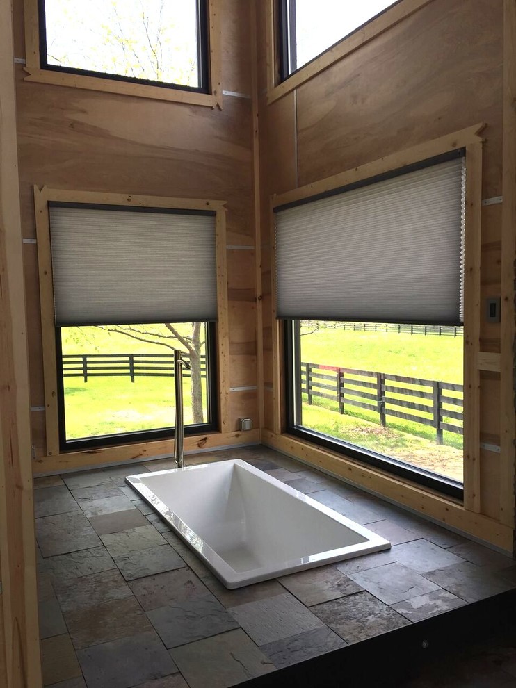 Modelo de cuarto de baño principal rústico de tamaño medio con bañera encastrada, ducha a ras de suelo, lavabo integrado, encimera de cuarzo compacto, armarios con paneles lisos y puertas de armario negras