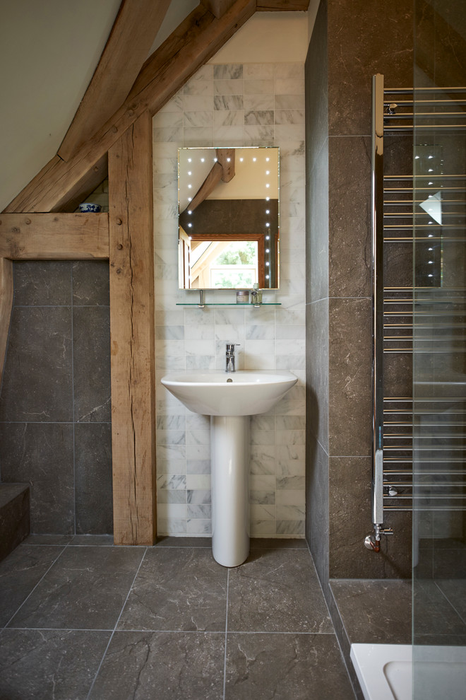На фото: ванная комната в стиле рустика с раковиной с пьедесталом и зеркалом с подсветкой