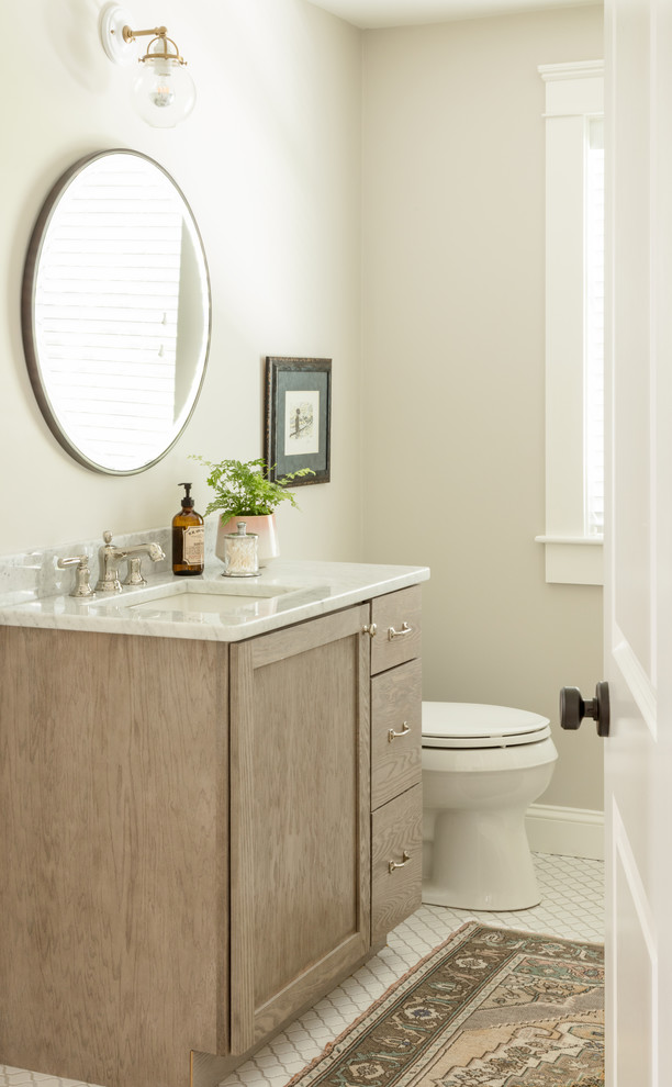 Cette image montre une salle de bain traditionnelle en bois clair avec un placard à porte plane, une baignoire posée, WC à poser, un mur gris, un sol en carrelage de céramique, un lavabo encastré, un plan de toilette en marbre, un sol blanc et une cabine de douche avec un rideau.