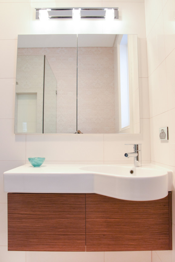 Esempio di una stanza da bagno minimal con ante lisce, ante in legno scuro, doccia ad angolo, piastrelle bianche, piastrelle in gres porcellanato, lavabo integrato e porta doccia a battente