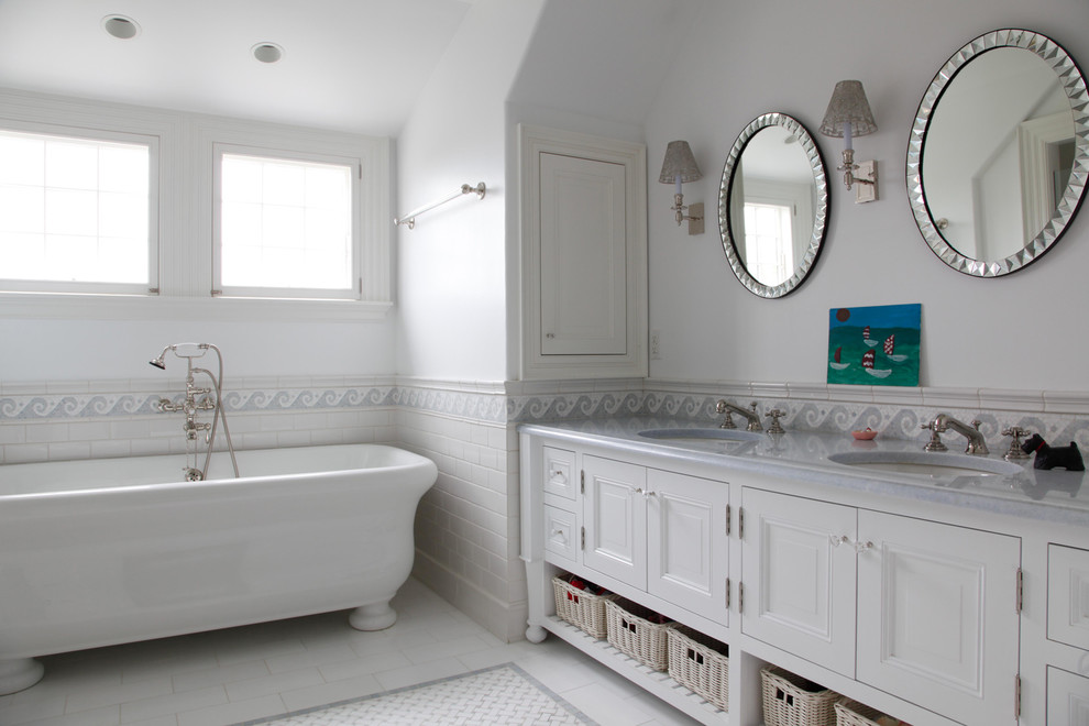 Design ideas for a coastal bathroom in Boston with recessed-panel cabinets, white cabinets, a freestanding bath, white tiles, metro tiles, white walls, a submerged sink and white floors.