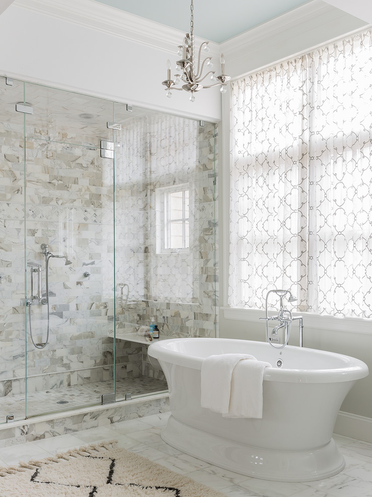 This is an example of a bathroom in Boston with a freestanding bath, an alcove shower, white tiles, white walls, white floors and a hinged door.