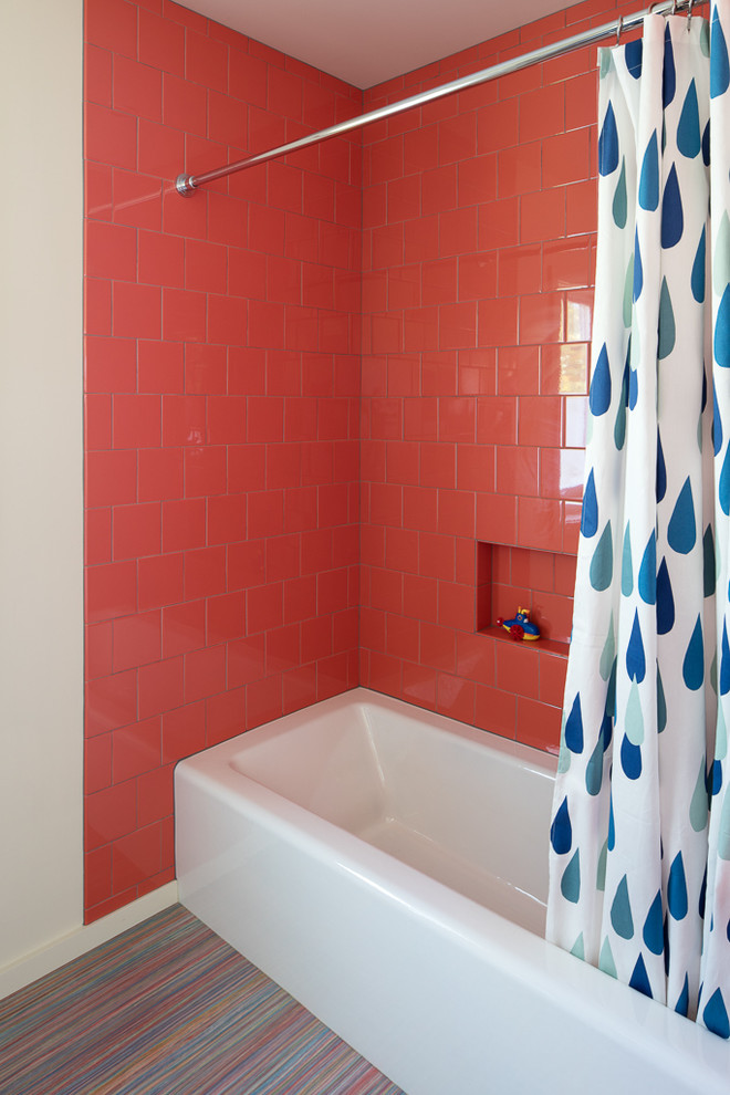 Modern inredning av ett mellanstort badrum för barn, med släta luckor, vita skåp, en dusch/badkar-kombination, orange kakel, porslinskakel, vita väggar, linoleumgolv, ett undermonterad handfat, bänkskiva i återvunnet glas och flerfärgat golv