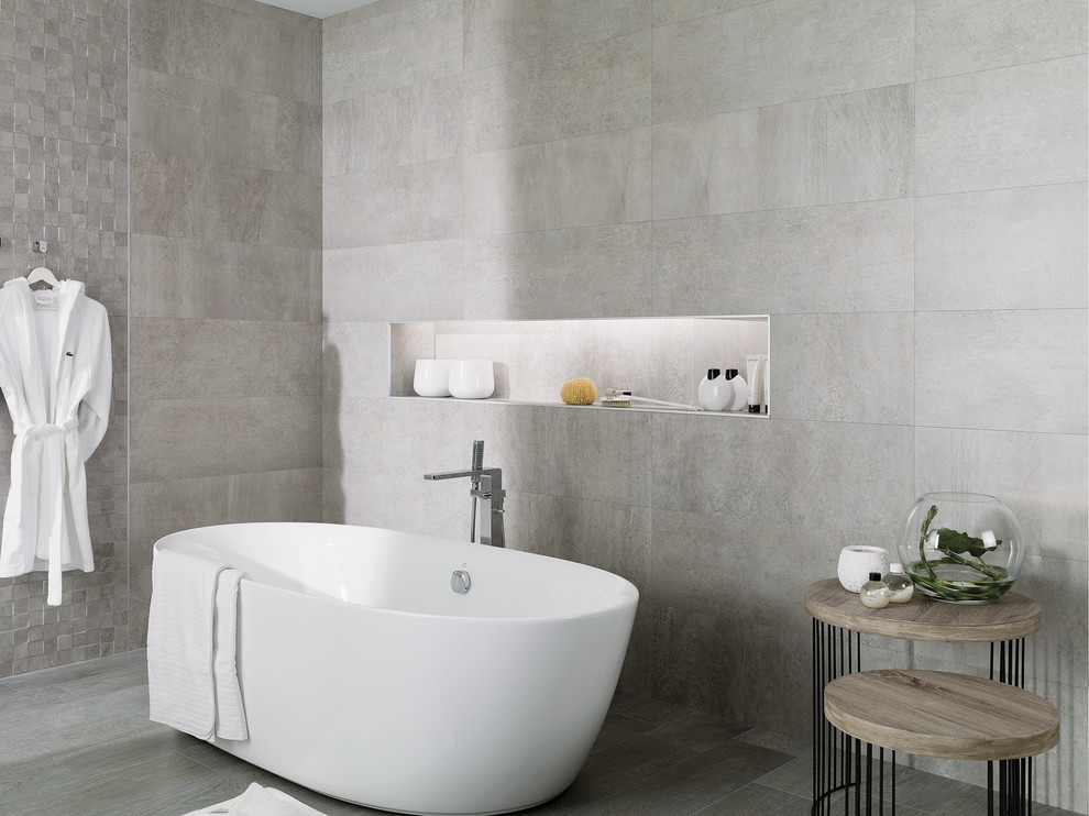 Inspiration pour une grande salle de bain principale urbaine avec un carrelage gris, une baignoire indépendante, un mur gris, un sol en carrelage de porcelaine, des carreaux de céramique et une douche ouverte.