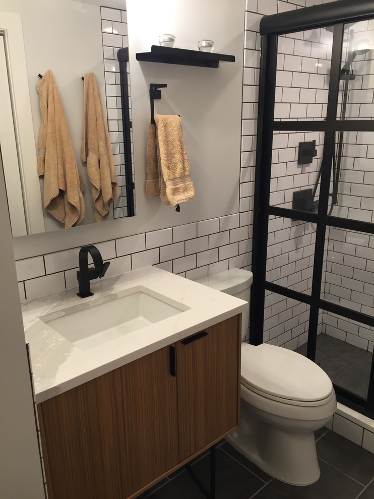 Idéer för att renovera ett litet funkis badrum, med en toalettstol med separat cisternkåpa, vit kakel, keramikplattor, klinkergolv i porslin, ett undermonterad handfat, grått golv, dusch med skjutdörr och bänkskiva i kvarts