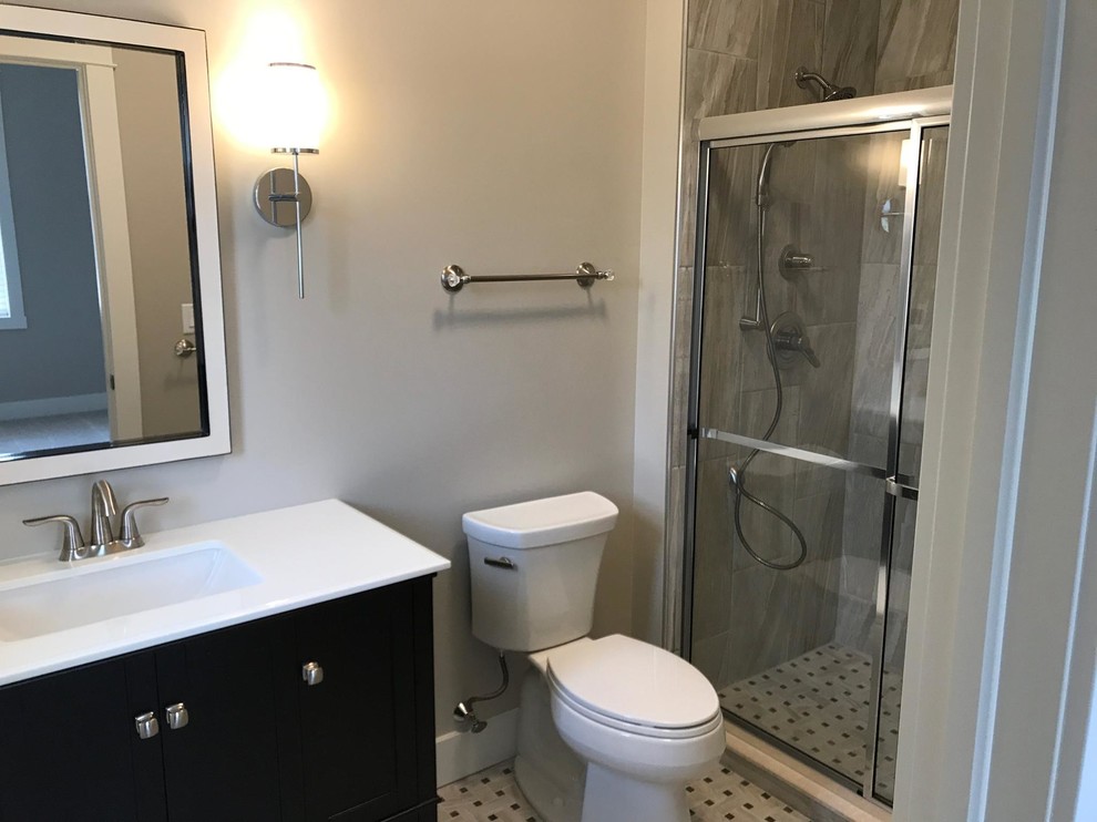 Small classic ensuite bathroom in Other with shaker cabinets, black cabinets, a double shower, a two-piece toilet, grey tiles, porcelain tiles, grey walls, porcelain flooring, an integrated sink, engineered stone worktops, multi-coloured floors and a sliding door.