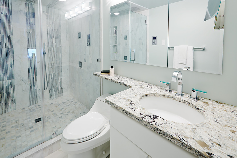 Exempel på ett mellanstort modernt badrum med dusch, med luckor med upphöjd panel, vita skåp, en dusch i en alkov, blå kakel, vit kakel, stickkakel, grå väggar, ett undermonterad handfat, granitbänkskiva och dusch med gångjärnsdörr