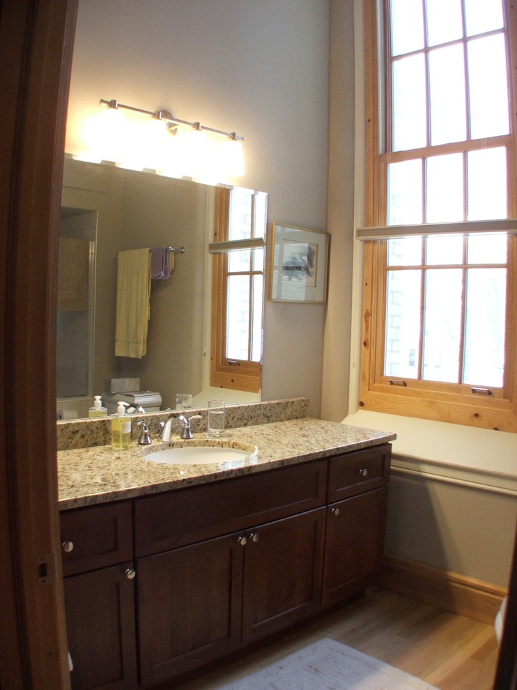 Example of a classic bathroom design in Grand Rapids with an undermount sink, shaker cabinets, dark wood cabinets, granite countertops and a two-piece toilet