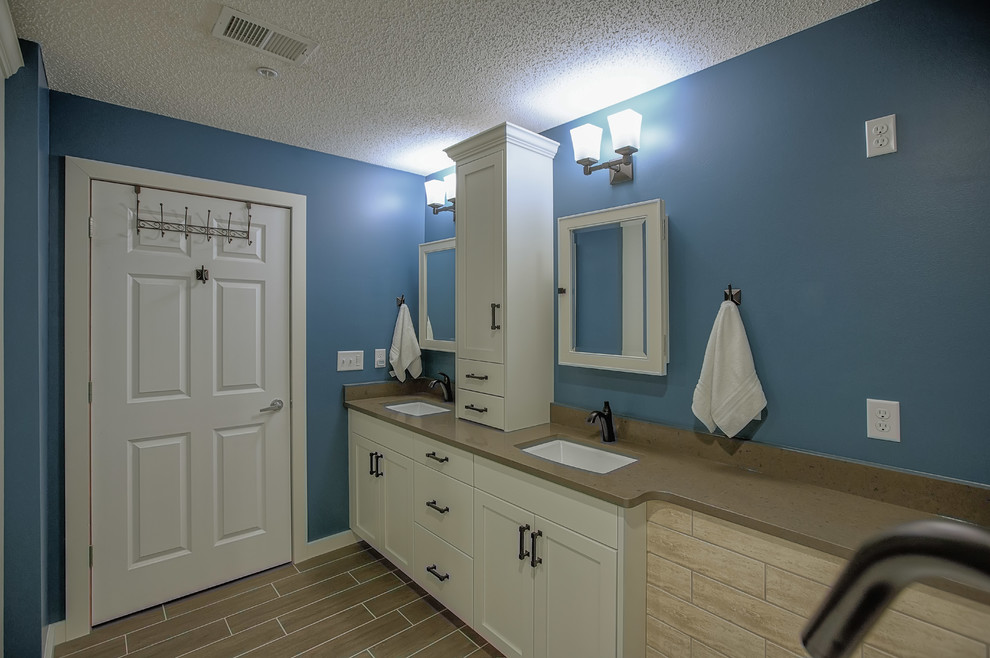 На фото: главная ванная комната среднего размера в стиле неоклассика (современная классика) с фасадами в стиле шейкер, белыми фасадами, отдельно стоящей ванной, угловым душем, раздельным унитазом, бежевой плиткой, керамогранитной плиткой, синими стенами, полом из керамогранита, врезной раковиной, столешницей из искусственного кварца, коричневым полом и душем с распашными дверями с