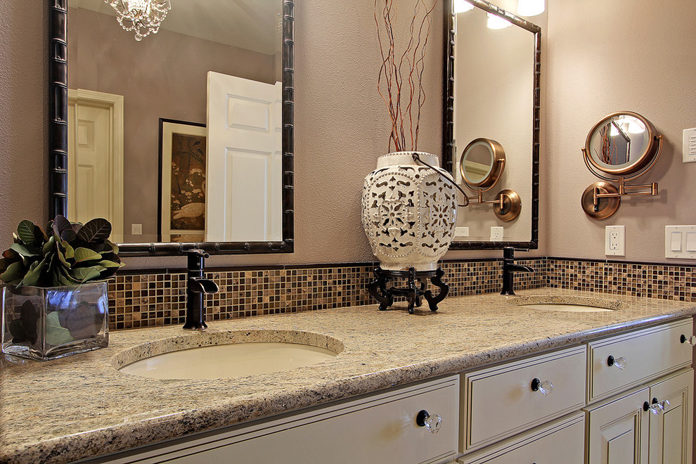 Immagine di una stanza da bagno padronale contemporanea di medie dimensioni con lavabo sottopiano, ante con finitura invecchiata, piastrelle beige, lastra di vetro e pareti grigie